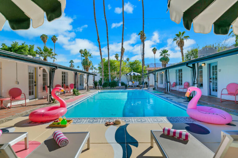 Stay Wandery Palm Springs villa pool with palm trees and flamingo floats