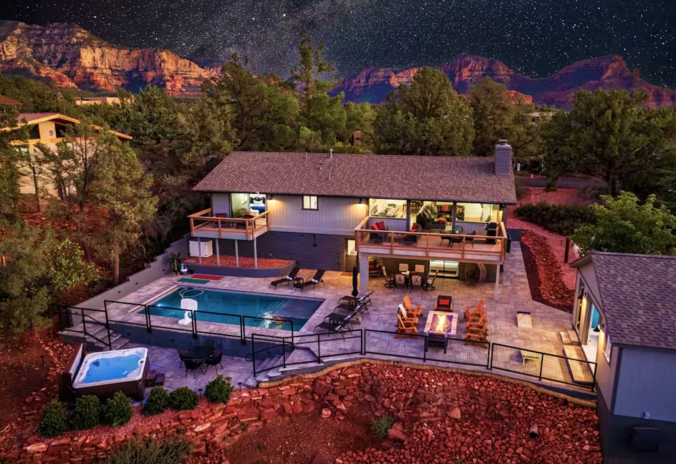 outdoor view of a vacation rental property featuring a large pool, a hot tub, and a fire pit.