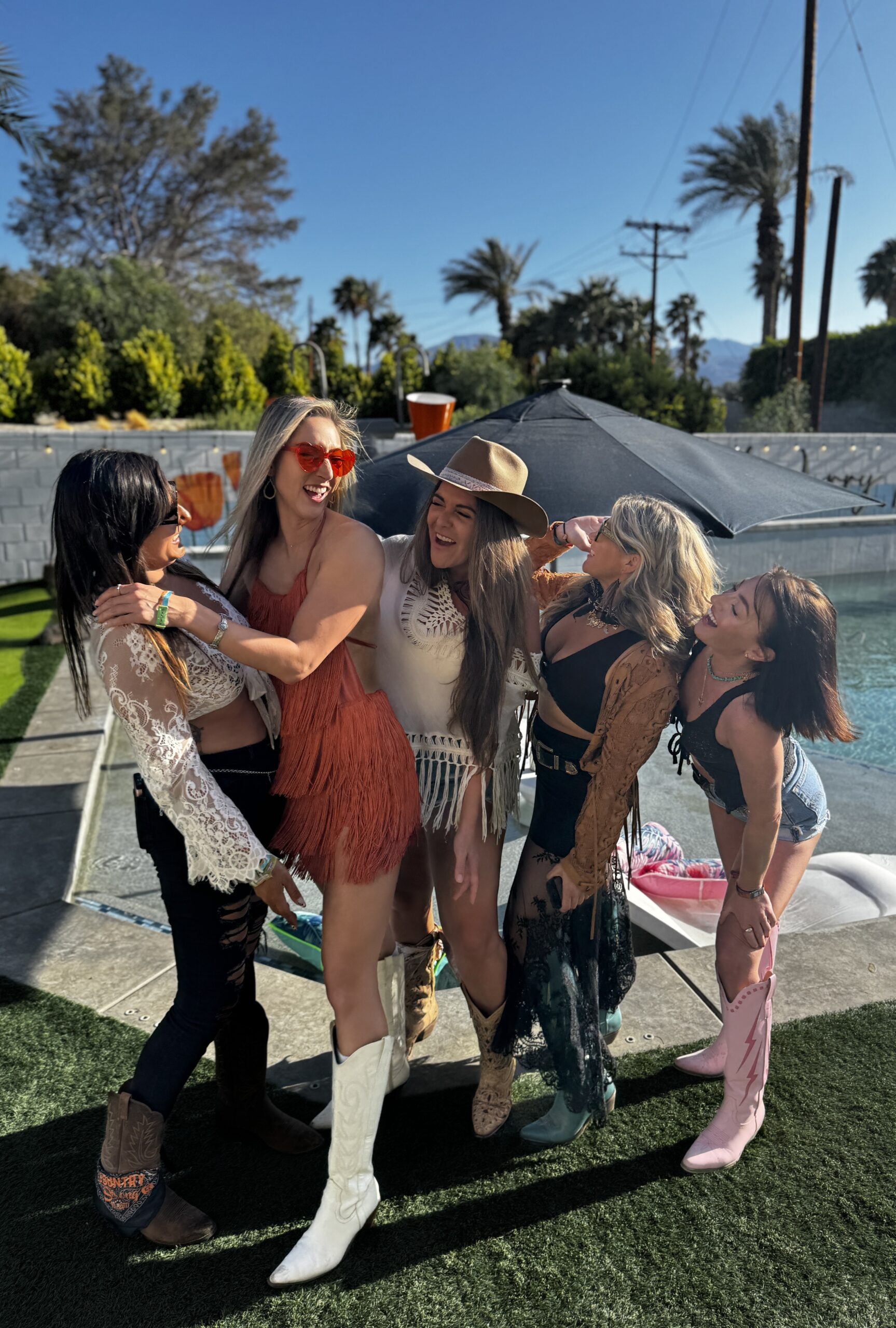 Group of friends at an Airbnb with a pool, excited for Coachella