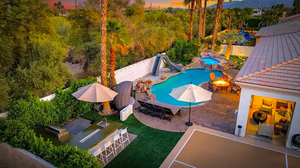 vacation rental property featuring a swimming pool with a slide and a spa.