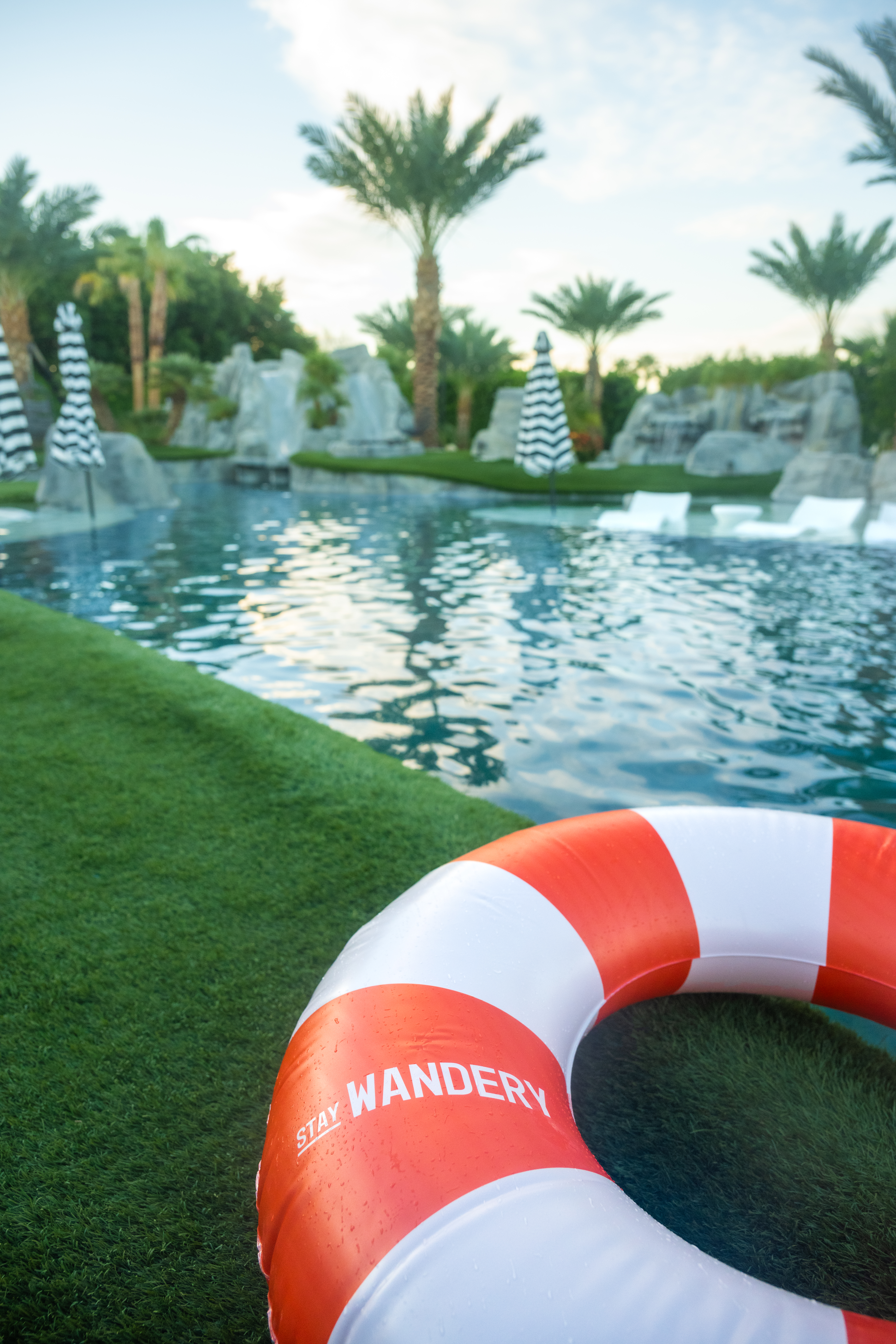Inflatable pool ring next to a pool with palm trees